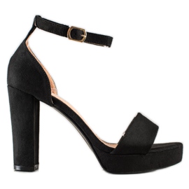 Weide Schwarze Sandalen auf einer Bar