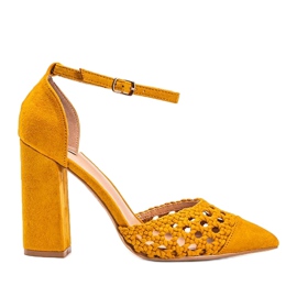 Senffarbene durchbrochene Pumpen an der Hana-Säule gelb