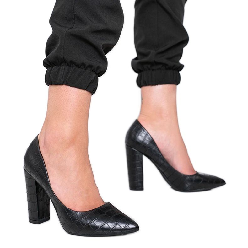 Schwarze Pumps an einem Pfosten mit Schlangenhautmuster This Way