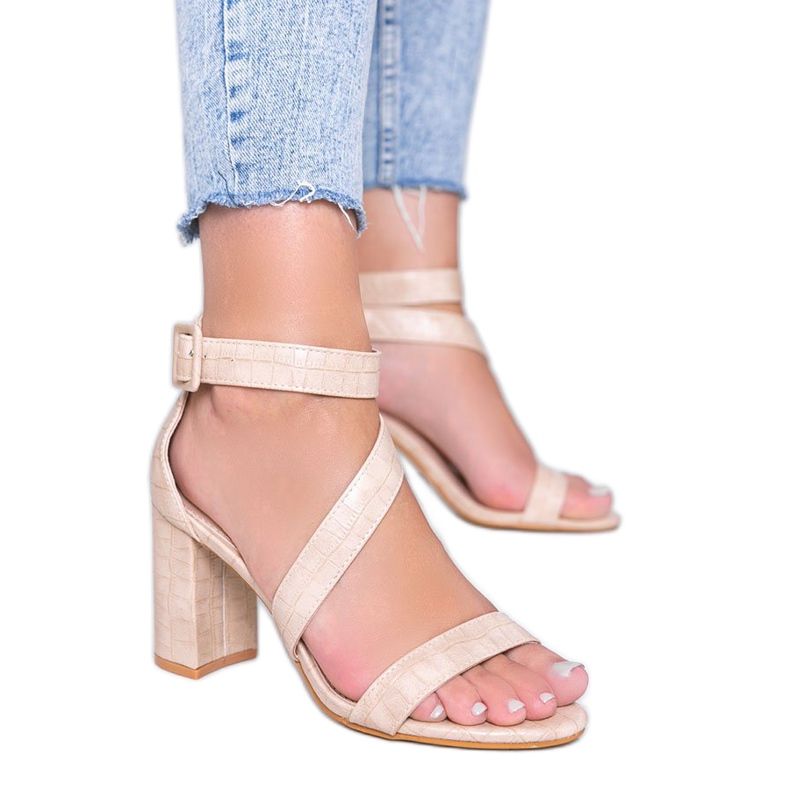 Beige Sandalen auf einem Silver Dust Pfosten