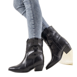 Schwarze Cowboystiefel auf einem Perlagepfosten