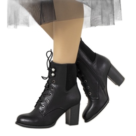 Schwarze Stiefeletten am Vedette-Pfosten