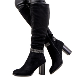 Schwarze Stiefel auf dem Pfosten von isoliertem Alexis