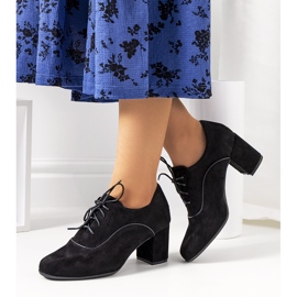 Schwarze Schuhe auf dem Vogelpfosten