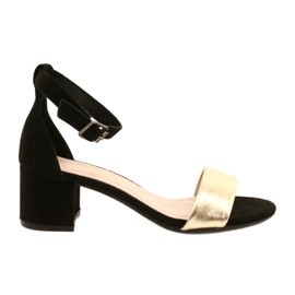 Schwarze und goldene Sandalen auf einer Bar Evento 20SD98-1618