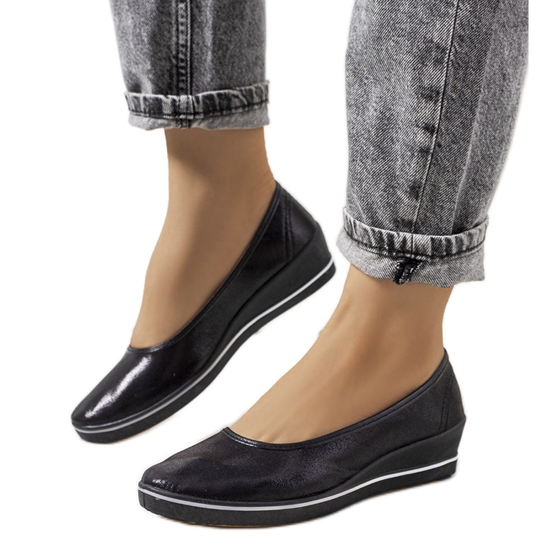 Schwarz glänzende Sneaker auf dem Weide Wedge