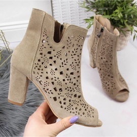 Durchbrochene Lederstiefel für Damen auf dem beigen Post von Juma