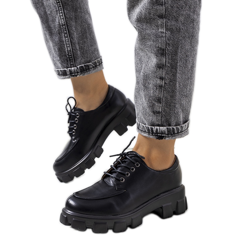 Schwarze Schuhe auf einer Feline-Traktorsohle