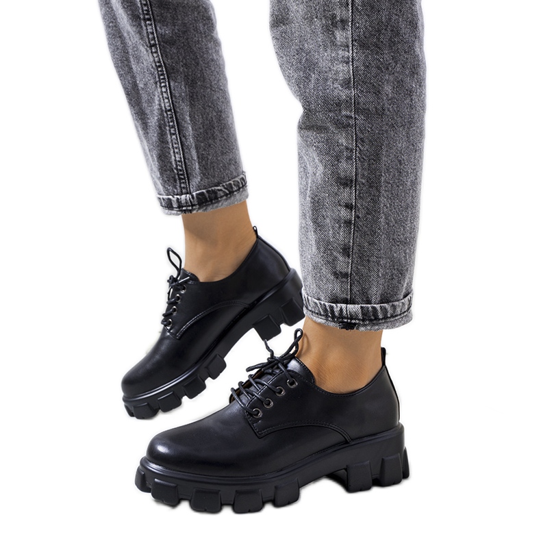 Schwarze Schuhe auf einer Chedi-Traktorsohle