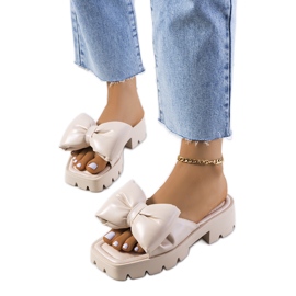 Beige Pantoffeln auf der Platt-Traktorsohle