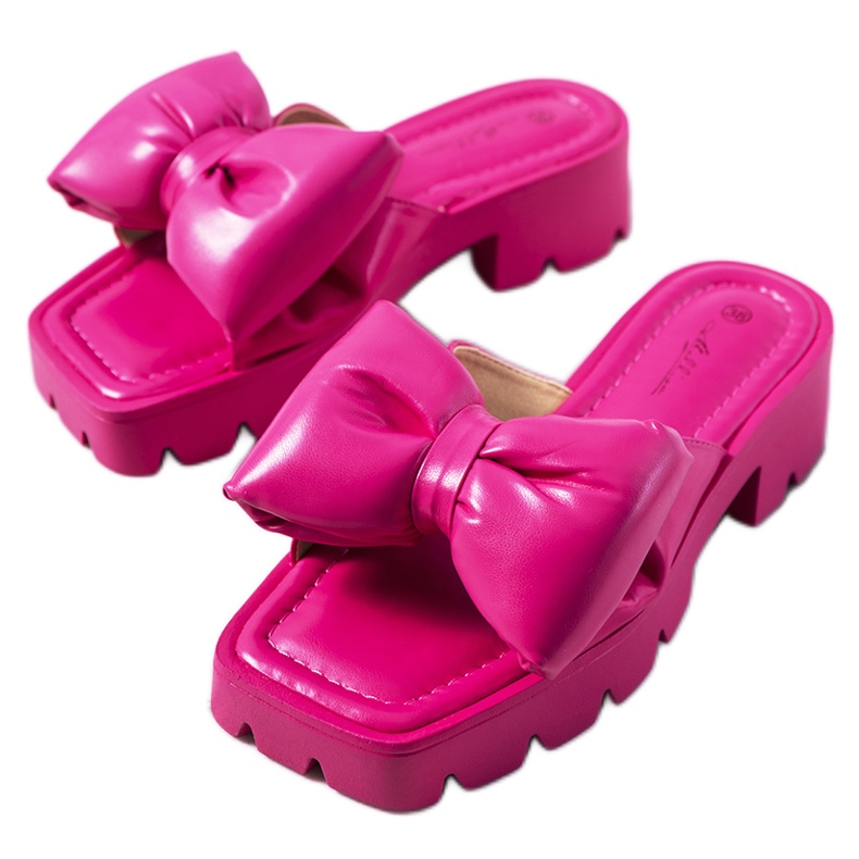 Rosa Pantoffeln auf der Platt-Traktorsohle