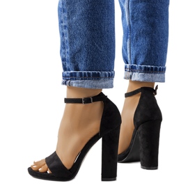 Schwarze Sandalen am Karida-Pfosten