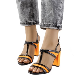 Orangefarbene Sandalen auf dem Puddy-Posten schwarz