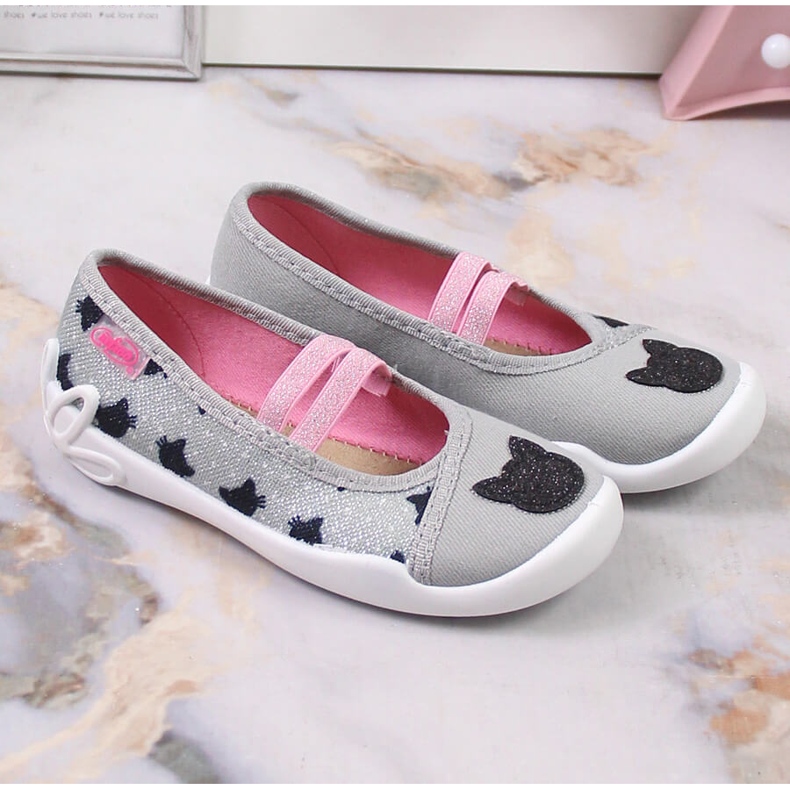 Mädchenhausschuhe an einem Gummiband mit einem Katzenslip auf grauem Befado