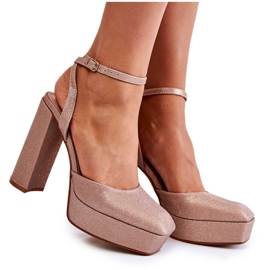 Glitzernde Damensandalen auf einer Fersen-Goldrosel golden