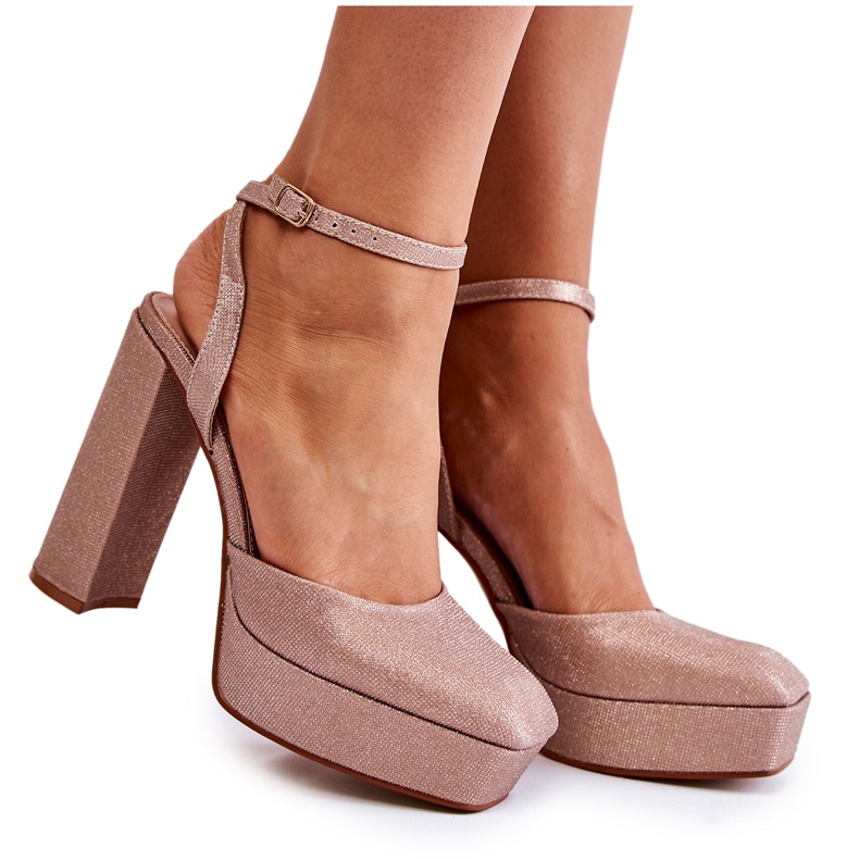 Glitzernde Damensandalen auf einer Fersen-Goldrosel golden