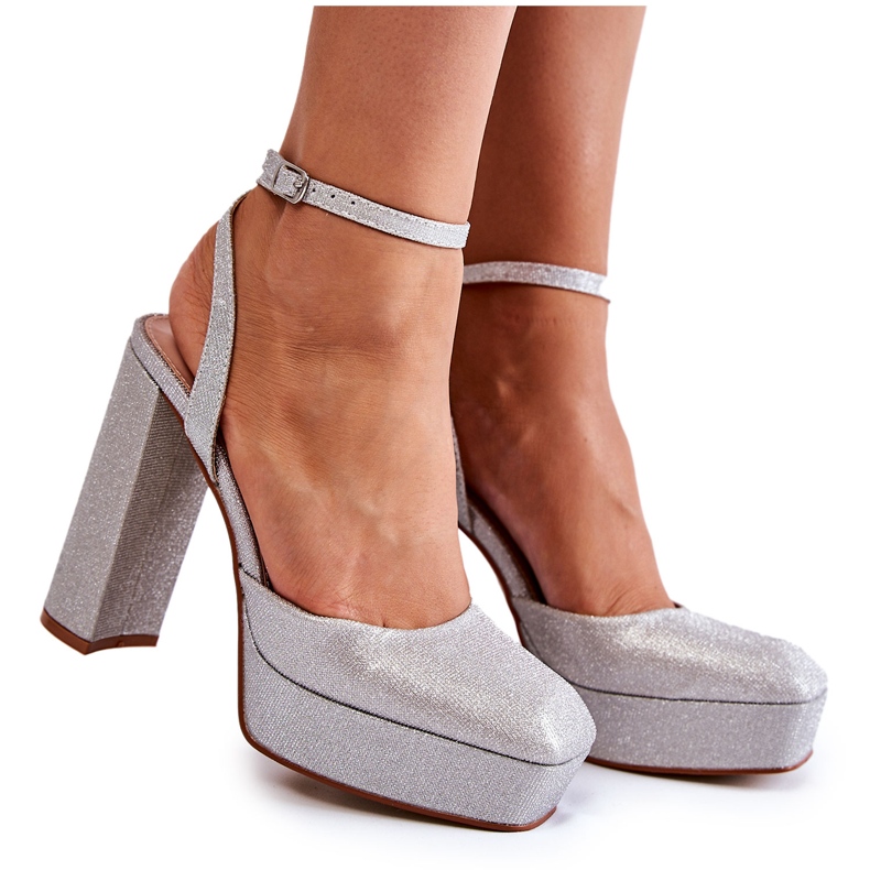 Glitzer -Sandalen von Frauen auf dem silbernen Beitrag silber-