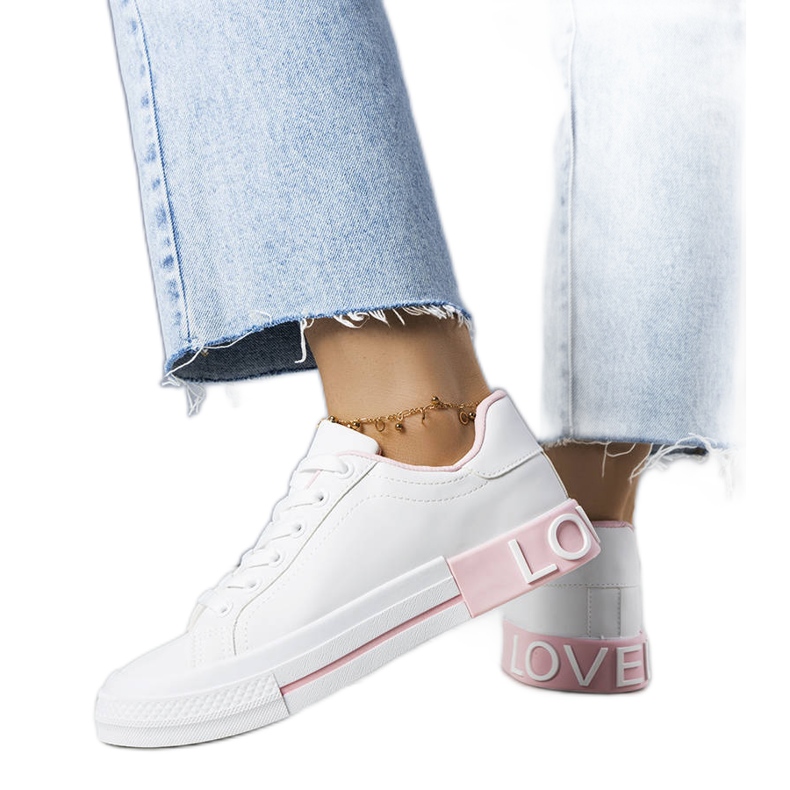 Weiße und rosa Turnschuhe, die mit der Nora-Inschrift verziert sind