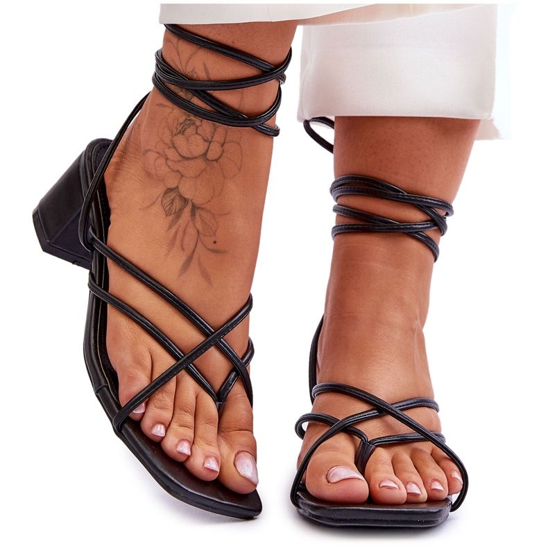 Gefesselte schwarze Sandalen mit hohen Absätzen und Flip-Flops. Geheime Liebe
