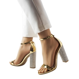 Goldene Sandalen auf einem dekorativen Rette-Pfosten