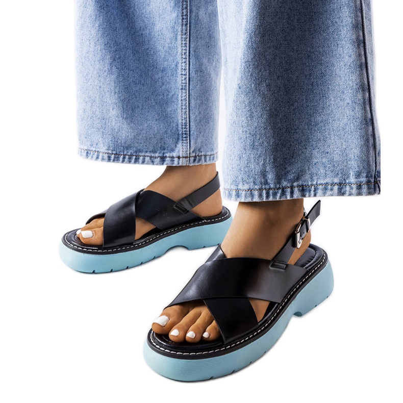 Schwarze Sandalen auf blauem Plateau von Rozana