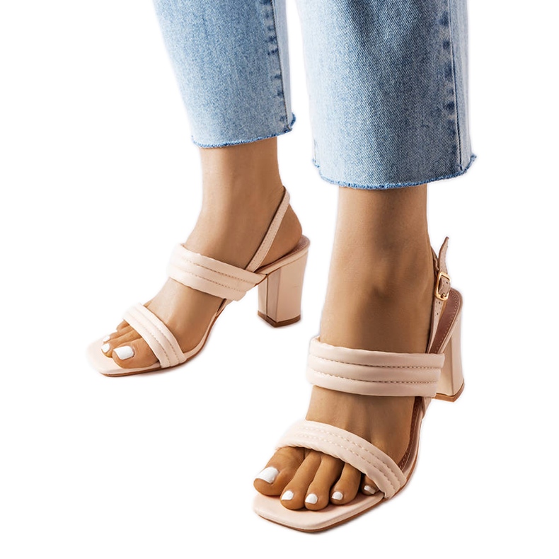 Beigefarbene Sandalen am Moli-Pfosten