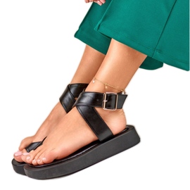 Schwarze Damensandalen, die am Knöchel von Lisa befestigt sind