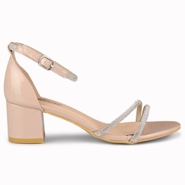 Elegante, glänzende beige Damensandalen am Pfosten