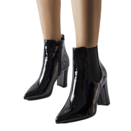 Schwarze Lackstiefel am Dolla-Pfosten