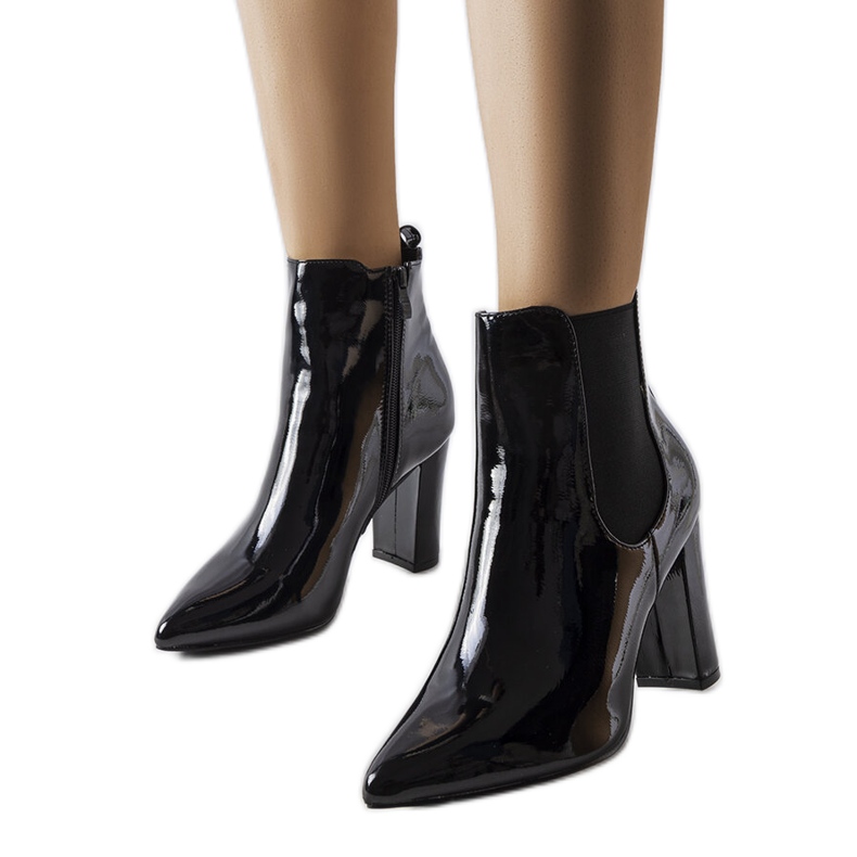 Schwarze Lackstiefel am Dolla-Pfosten