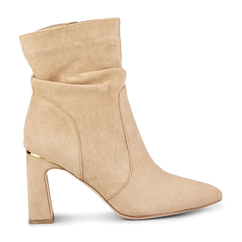 Beigefarbene Damenstiefel auf einem verzierten Pfosten