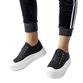 Schwarze Turnschuhe auf einem dicken weißen Rina-Plateau