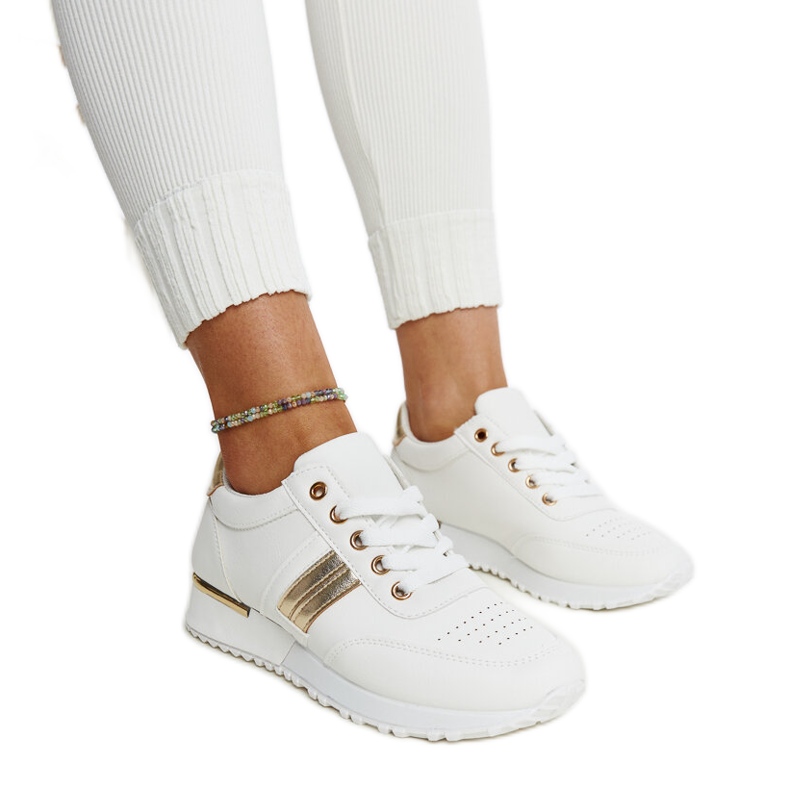 Weiß-goldene Sneakers auf der Nihad-Gummiplattform