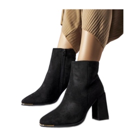 Schwarze Wildlederstiefeletten am Pfosten