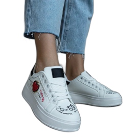 Weiße Sneakers, verziert mit einem Aufnäher und Aufschriften auf der Plattform