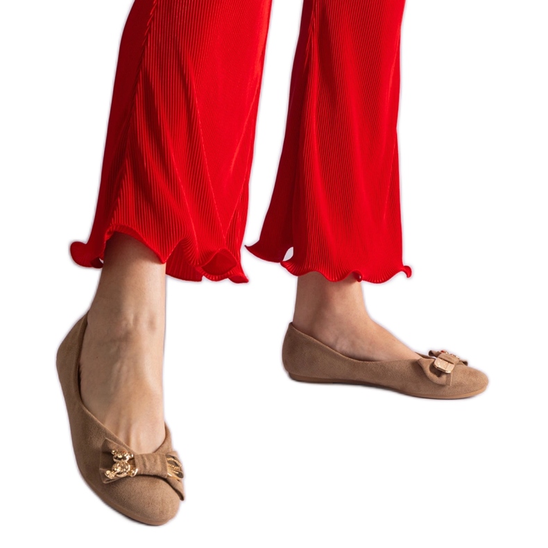 Beigefarbene Ballerinas, verziert mit einer Schleife und einer Brosche