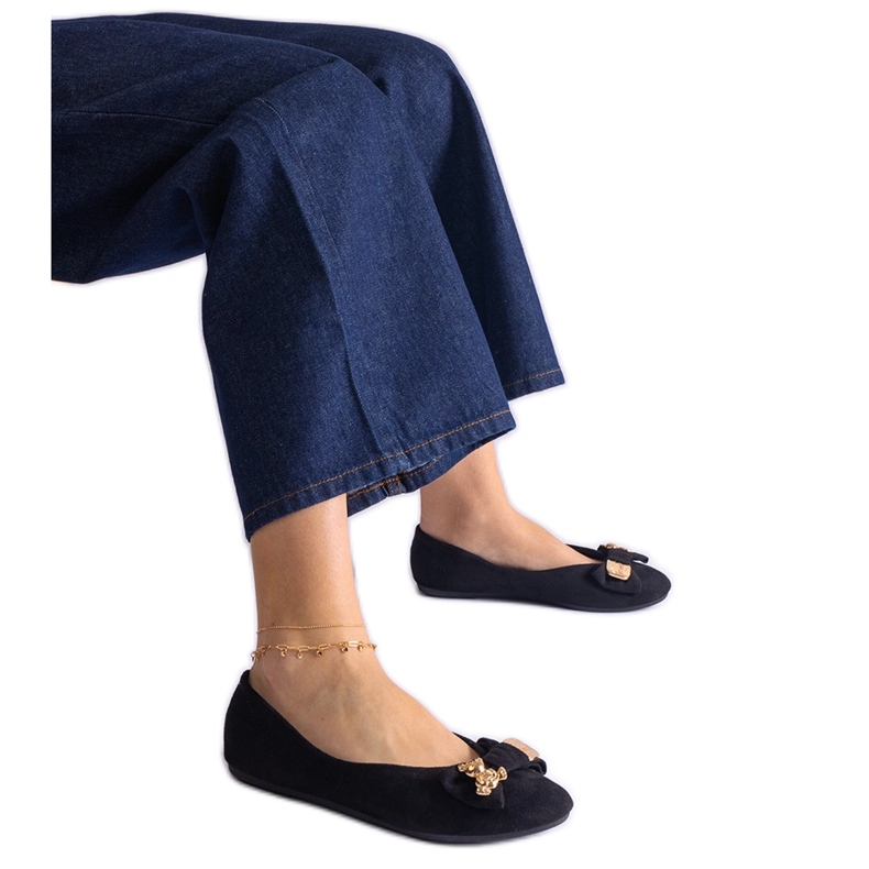 Schwarze Ballerinas, verziert mit einer Schleife und einer Brosche