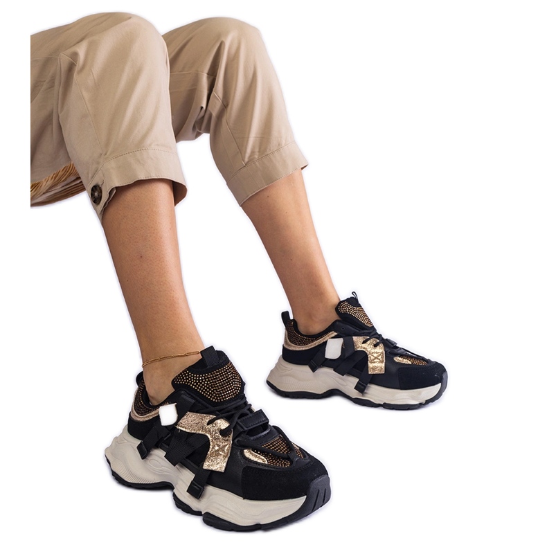 Schwarze Turnschuhe mit goldenen Einsätzen