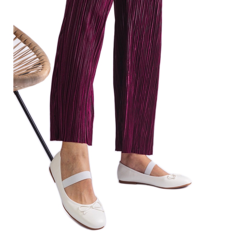 Weiße Ballerinas mit einem Gummiband und einem dekorativen Bogen