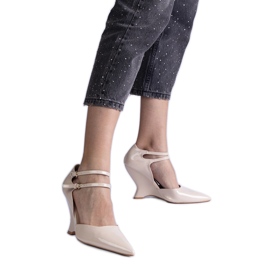 Beige Pumpen, die auf Keil mit Schnallen lackiert sind