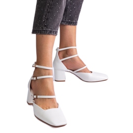 Weiße Pumpen auf der Säule mit Schnallen