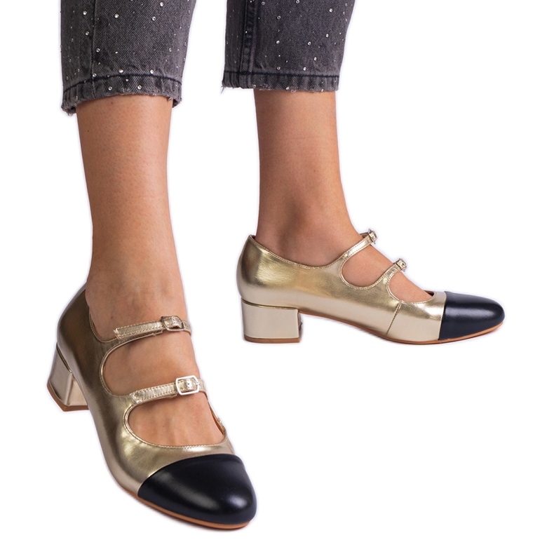 Goldene Pumpen auf einer schwarzen Nase