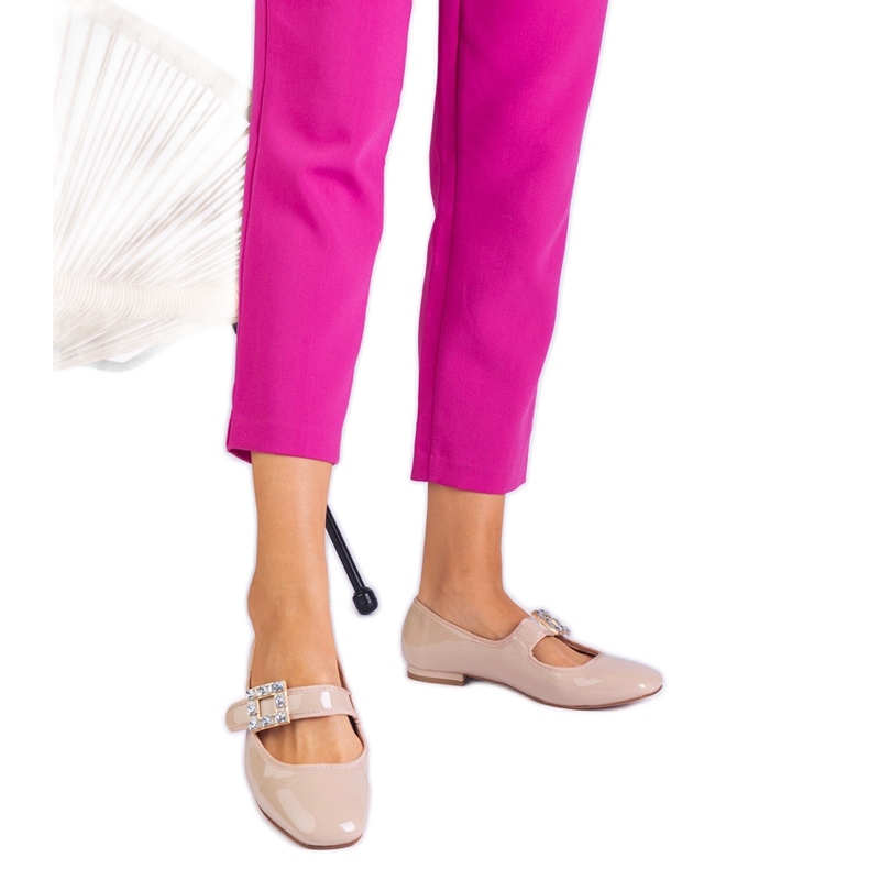 Beige lackierte Ballerinas mit einer Klemme dekoriert