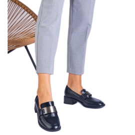 Schwarze Pumpen auf einem niedrigen Pfosten mit einer metallischen Dekoration