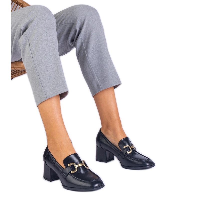 Schwarze Pumpen auf dem Pfosten mit einer metallischen Dekoration