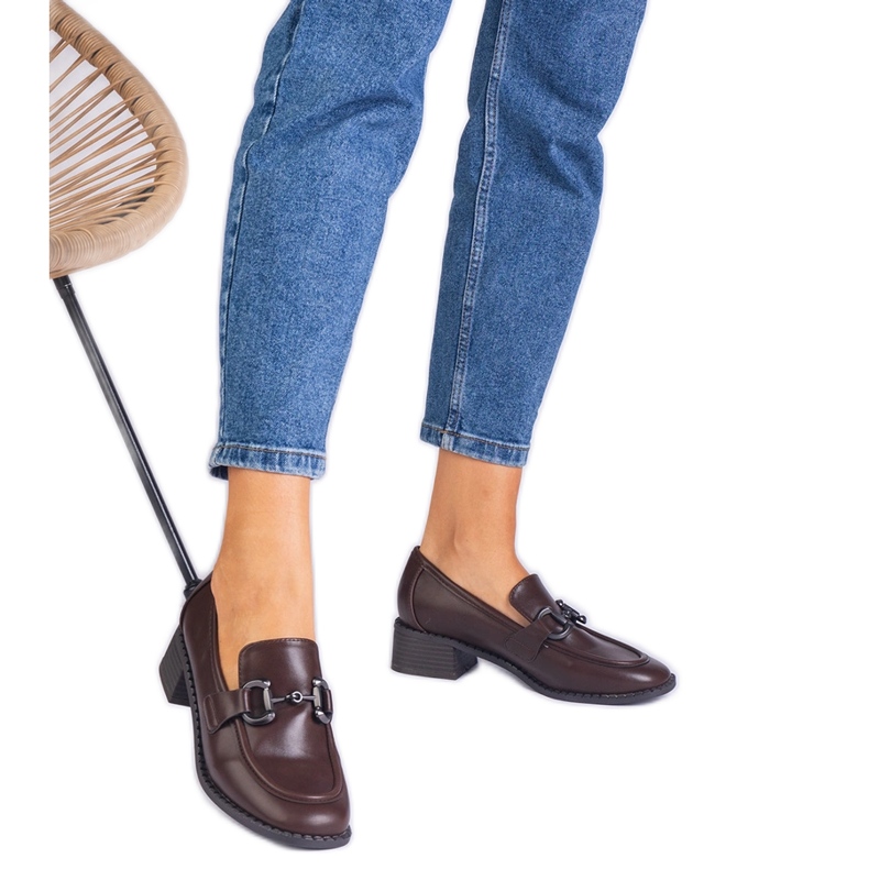 Braune Pumpen auf dem Pfosten mit einer metallischen Dekoration