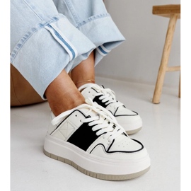 Weiße und weiße Leder -Turnschuhe auf der dicken Sohle von Abrar