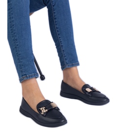 Schwarze Slaser mit einem Bug und einem goldenen Teddybär dekoriert