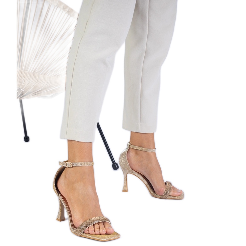 Golden elegante Sandalen auf einem mit Zirkonen dekorierten High Heel