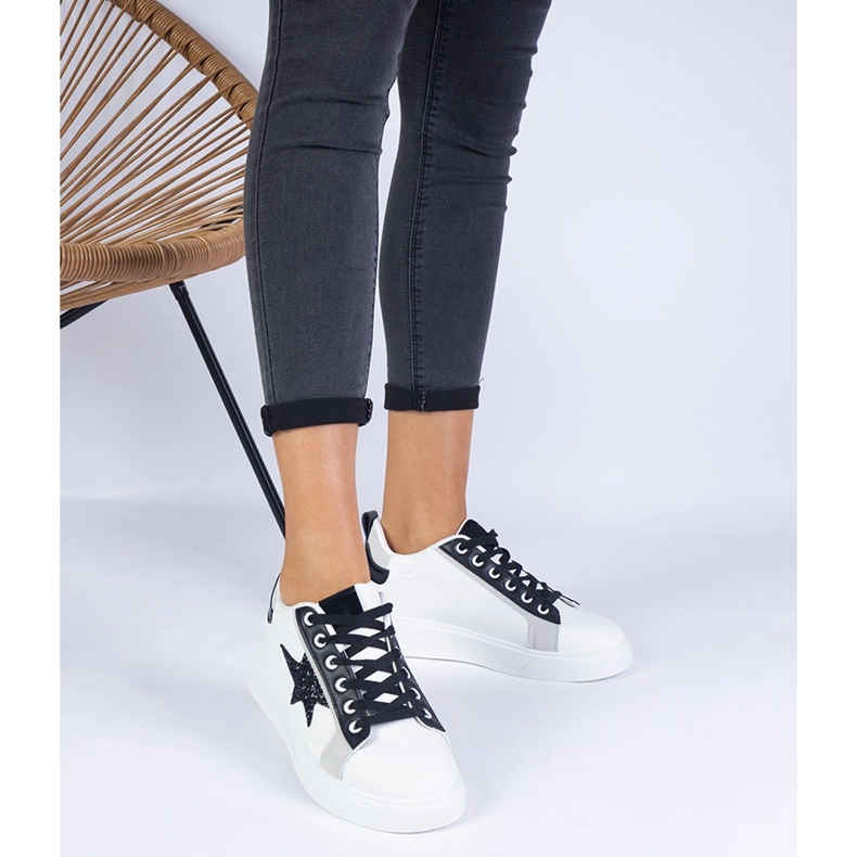 Weiße Turnschuhe mit einem Glitzerstern dekoriert